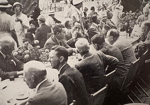 Black and white photo of men seated at a table